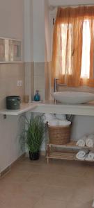 a bathroom with a sink and a shelf with towels at Neaktion Apartments in Nikiti