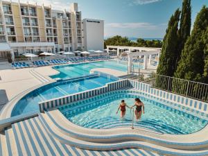 twee vrouwen in het zwembad in een hotel bij Bluesun Hotel Alga in Tučepi