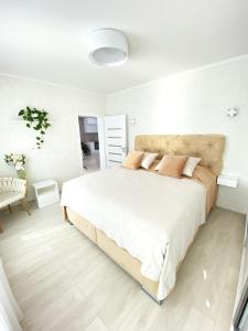 um quarto branco com uma cama grande e uma mesa em Die Eleganz - Exclusive Apartment near the City Center em Bratislava