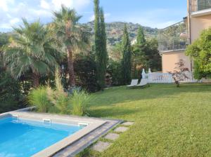 a yard with a swimming pool and a house at Il tempo di Zia Palmira - AGRITURISMO IL RISVEGLIO in Imperia