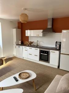 een keuken met witte kasten en een fornuis met oven bij Terra Residence - Superbe, calme et lumineux in Thonon-les-Bains
