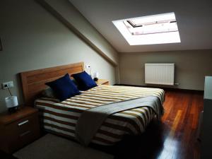 una camera da letto con un grande letto con cuscini blu di Ático Río Pego a Ángeles