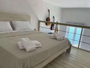 a bedroom with a large bed with towels on it at MARE DI NAPOLI in Pozzuoli