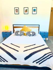 a bed with a black and white blanket on it at Modern chic summer holiday retreat. in Newquay