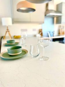 a table with plates and glasses on a counter at Modern chic summer holiday retreat. in Newquay