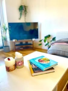 a table with a book and a candle on it at Modern chic summer holiday retreat. in Newquay