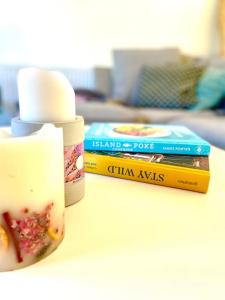 a table with a bottle of jam and two books at Modern chic summer holiday retreat. in Newquay