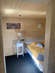 een kleine slaapkamer met een bed en een tafel bij Seaside holiday home Vecvalki in Saunags