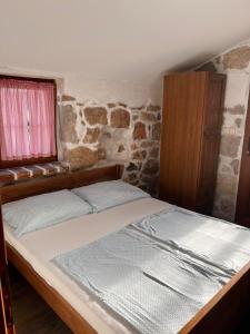 a bed in a room with a stone wall at konoba in Rab +22 photos