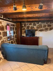 a blue couch in a living room with a tv at konoba in Rab