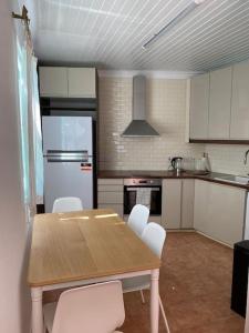 eine Küche mit einem Holztisch und weißen Geräten in der Unterkunft Spitaki in Polis Chrysochous