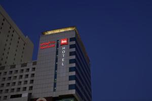 ibis Kuwait Salmiya في الكويت: مبنى طويل عليه علامة الفندق