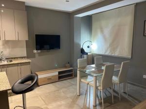 a kitchen with a table and chairs and a television at APARTAMENTOS CAMINO A RIBEIRA in Quiroga