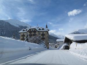 una carretera cubierta de nieve frente a un edificio en Hotel Schweizerhof Sta Maria en Sta Maria Val Müstair