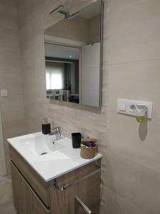 a bathroom with a sink and a mirror at APARTAMENTOS CAMINO A RIBEIRA in Quiroga