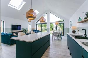 an open kitchen and living room with a large island at Saltwhistle - Bracklesham Bay in Chichester