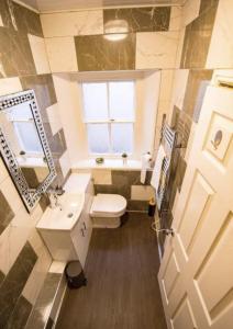 een badkamer met een toilet, een wastafel en een raam bij Truro Central Studios in Truro