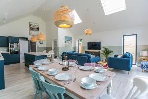 a dining room and living room with a table and chairs at Saltwhistle - Bracklesham Bay in Chichester