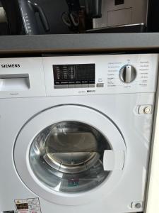 a washing machine with its door open in a kitchen at Traumhafte Haushälfte mit Kamin, Garten & Whirlpool in Berlin