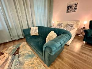 a green couch in a living room with a bed at Kings main square Apartment in Poprad