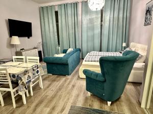 a bedroom with a bed and two chairs and a couch at Kings main square Apartment in Poprad