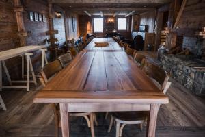 a long wooden table in a room with chairs at Alpage la Grand Montagne 1858 in Le Grand-Bornand