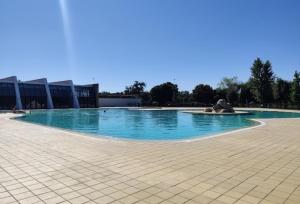 a large pool with blue water in front of a building at MY DREAM in Alcains