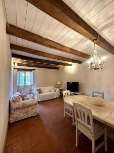 a living room with a table and chairs and a couch at Casa vacanze Ca' del Poggio in Loiano
