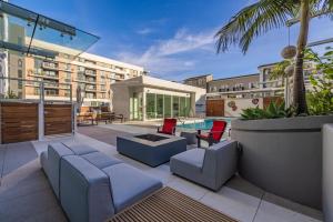 a patio with furniture and a pool in a building at @ Marbella Lane - Luxury Beachside 2BR in Long Beach
