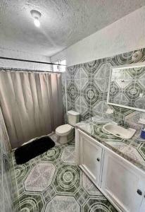 a bathroom with a toilet and a tiled floor at Apartment located two blocks from the sea in Cozumel