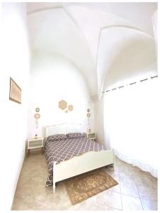 1 dormitorio con 1 cama en una habitación blanca en Casa Vacanze Patrizia, en Botrugno