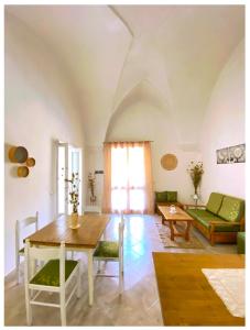sala de estar con mesa y sofá verde en Casa Vacanze Patrizia, en Botrugno