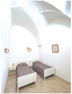 um quarto com duas camas e um relógio na parede em Casa Vacanze Patrizia em Botrugno