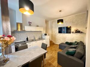 uma cozinha e uma sala de estar com um sofá e uma mesa em Romeo apartments Rovigno em Rovinj