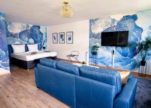 a living room with a blue couch and a bed at City Loft - 5 Min Rhein-Galerie in Ludwigshafen am Rhein