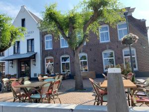 a group of tables and chairs in front of a building at huisje in zeeland helemaal gerenoveerd in Sint Annaland