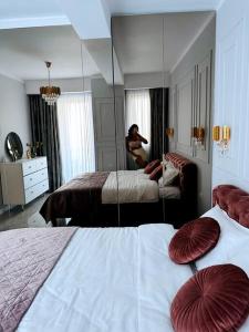 Habitación de hotel con 2 camas y espejo en Premium Aparthotel La Mirada, en Mamaia Nord – Năvodari