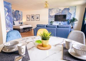 sala de estar con mesa y sillas azules en City Loft - 5 Min Rhein-Galerie, en Ludwigshafen am Rhein
