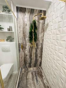 y baño con ducha y pared de piedra. en Premium Aparthotel La Mirada, en Mamaia Nord – Năvodari