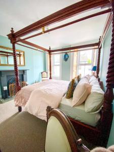 a bedroom with a canopy bed with pillows at Rose House in Glenarm