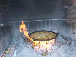 una gran pizza cocinando en un horno de ladrillo en Casa Los Geranios, en Cullera