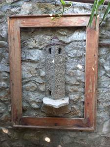 un mur en pierre avec une maison ornithologique. dans l'établissement HeArt of Old Town Guesthouse, à Podgorica