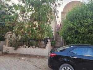 十月六日城的住宿－Privat apartment beside mall of egypt，停在大楼前的一辆黑色汽车