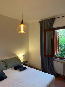 1 dormitorio con cama blanca y ventana en B&B RIO GRANDE, en Massarosa