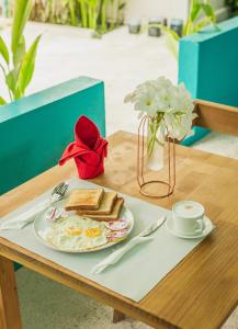 a table with a plate of toast and a cup of coffee at Palm Rest Maldives in Magoodhoo