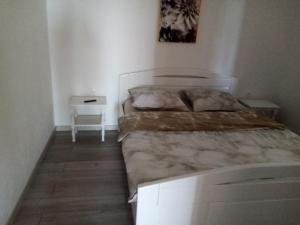 a bedroom with a large bed and a night stand at NATALIJA - holiday house with garage in Sveti Juraj