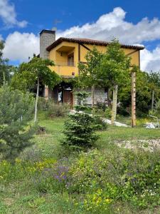 a yellow house on top of a field with flowers at Hospederia La Serrota in Narros del Puerto