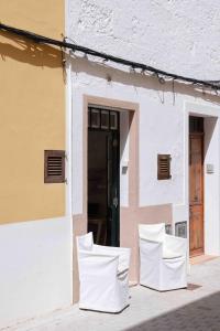 two white chairs sitting outside of a building at Pere Alcantara 40, 3 bedroom house, Ciutadella in Ciutadella