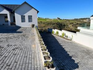 a house with a cobblestone driveway in front of a house at Metanoia Kingswood Golf Estate in George