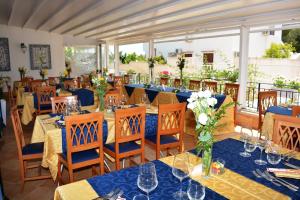 - un restaurant avec des tables bleues et des chaises fleuries dans l'établissement Hotel Ristorante Mediterraneo Faro, à San Vito Lo Capo
